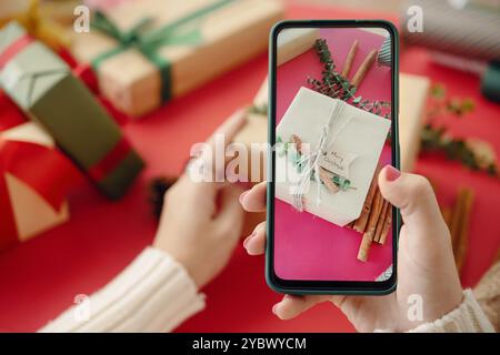 Weihnachtsgeschenke auf dem Smartphone erfassen Stockfoto