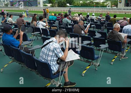 Hongkong, China. Oktober 2024. Die Zuschauer des Pferderennsports sitzen auf der Plattform der Sha Tin Racecourse. Die SHA Tin Racecourse ist eine der beiden Pferderennen in Hongkong. Es befindet sich in Sha Tin und wird vom Hong Kong Jockey Club verwaltet. (Kreditbild: © Keith Tsuji/ZUMA Press Wire) NUR REDAKTIONELLE VERWENDUNG! Nicht für kommerzielle ZWECKE! Stockfoto