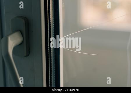 Glas, das von Hooligans gebrochen wurde, in einem Metall-Kunststoff-Fenster, Nahaufnahme. Hochwertige Fotos Stockfoto