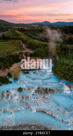 Entspannen Sie sich im warmen, mineralreichen Wasser der Thermalbäder von Saturnia in der Toskana, umgeben von üppigem Grün und einem rustikalen Gebäude, das einen tr Stockfoto