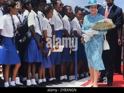 Eine Reihe lokaler Studenten und Schüler begrüßt eine lächelnde Königin Elizabeth II. Bei ihrem Besuch am Queen's College. Die Königin war auf ihrem letzten Besuch auf der Karibikinsel Barbados. Bis 11. März 1989. Stockfoto