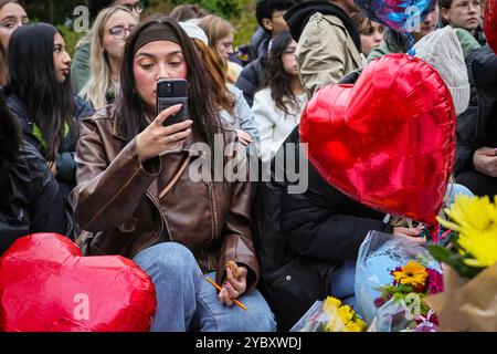 London, Großbritannien. Oktober 2024. Fans treffen sich im Hyde Park für eine Gedenkwache an der Peter-Pan-Statue, bei der Blumen, Ballons und Erinnerungsstücke hinterlassen werden. Es wurde geschätzt, dass in den ersten Stunden mehr als 2000 Trauernde an der Mahnwache teilnahmen. Der ehemalige One-Direction-Star Liam Payne starb im Alter von 31 Jahren in Buenos Aires, Argentinien, letzten Mittwoch, nachdem er von einem Balkon gefallen war, die Umstände seines Todes sind noch nicht vollständig geklärt. Quelle: Imageplotter/Alamy Live News Stockfoto