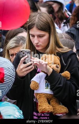 London, Großbritannien. Oktober 2024. Fans treffen sich im Hyde Park für eine Gedenkwache an der Peter-Pan-Statue, bei der Blumen, Ballons und Erinnerungsstücke hinterlassen werden. Es wurde geschätzt, dass in den ersten Stunden mehr als 2000 Trauernde an der Mahnwache teilnahmen. Der ehemalige One-Direction-Star Liam Payne starb im Alter von 31 Jahren in Buenos Aires, Argentinien, letzten Mittwoch, nachdem er von einem Balkon gefallen war, die Umstände seines Todes sind noch nicht vollständig geklärt. Quelle: Imageplotter/Alamy Live News Stockfoto