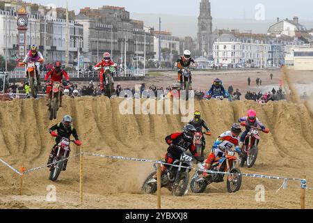 Weymouth, Dorset, Großbritannien. Oktober 2024. Mehr als 300 Fahrer, die von Tausenden von Zuschauern beobachtet werden, nehmen am 40. Motocross-Rennen in Weymouth Beach Teil, auf einem provisorischen Golfplatz, der von Baggern aus dem goldenen Sand des Resorts geschnitzt wurde. Die jährliche kostenlose Veranstaltung wird vom Purbeck Motocross Club veranstaltet. Bildnachweis: Graham Hunt/Alamy Live News Stockfoto