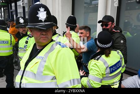 Brighton UK 7. August 2024 - Ein örtlicher Händler, der in der Nähe arbeitete, wird von den Protesten verwickelt und wird von der Polizei geschützt, da Antirassisten gegen die jüngsten rechtsextremen Demonstrationen in ganz Großbritannien protestieren . Seit der Ermordung von 3 Kindern in Southport im Juli gab es Rassenunruhen : Stockfoto