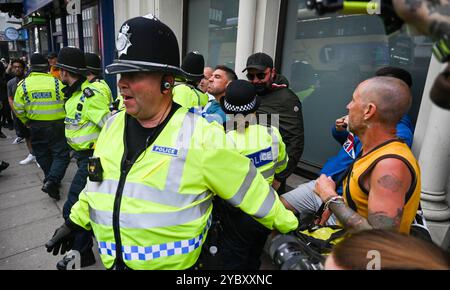 Brighton UK 7. August 2024 - Ein örtlicher Händler, der in der Nähe arbeitete, wird von den Protesten verwickelt und wird von der Polizei geschützt, da Antirassisten gegen die jüngsten rechtsextremen Demonstrationen in ganz Großbritannien protestieren . Seit der Ermordung von 3 Kindern in Southport im Juli gab es Rassenunruhen : Stockfoto