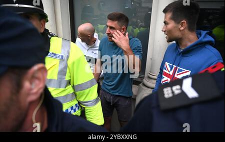 Brighton UK 7. August 2024 - Ein örtlicher Händler, der in der Nähe arbeitete, wird von den Protesten verwickelt und wird von der Polizei geschützt, da Antirassisten gegen die jüngsten rechtsextremen Demonstrationen in ganz Großbritannien protestieren . Seit der Ermordung von 3 Kindern in Southport im Juli gab es Rassenunruhen : Stockfoto