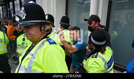 Brighton UK 7. August 2024 - Ein örtlicher Händler, der in der Nähe arbeitete, wird von den Protesten verwickelt und wird von der Polizei geschützt, da Antirassisten gegen die jüngsten rechtsextremen Demonstrationen in ganz Großbritannien protestieren . Seit der Ermordung von 3 Kindern in Southport im Juli gab es Rassenunruhen : Stockfoto