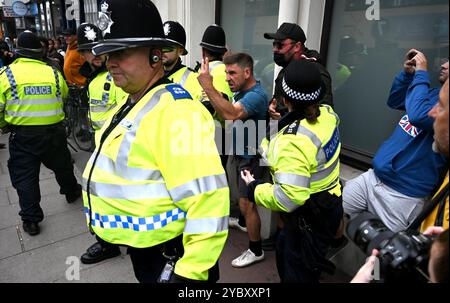 Brighton UK 7. August 2024 - Ein örtlicher Händler, der in der Nähe arbeitete, wird von den Protesten verwickelt und wird von der Polizei geschützt, da Antirassisten gegen die jüngsten rechtsextremen Demonstrationen in ganz Großbritannien protestieren . Seit der Ermordung von 3 Kindern in Southport im Juli gab es Rassenunruhen : Stockfoto