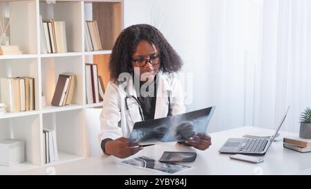 Medizinische Expertise. Pneumoniediagnostik. Klinische Praxis. Konzentrierte Pulmonologin bei der Untersuchung des Röntgenfilms der Lunge am Krankenhausarbeitsplatz. Stockfoto