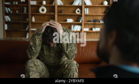 Besorgt depressiv frustriert kaukasischer trauriger verzweifelter Patient männlicher Klient Guy Militär Kampfuniform Armee Soldat Offizier mit Kopfschmerzen reden Stockfoto