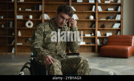 Trauriger ängstlicher kaukasischer Offizier Kampfuniform Mann mit Behinderung Militärsoldat Guy Veteran im Rollstuhl berührend Kinngesicht denken Stockfoto