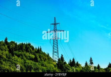 Hochspannungsleitung vor dem Hintergrund des blauen Himmels in den Bergen. Metalldrähte an einem Hochspannungsturm übertragen Elektrizität in großer Entfernung Stockfoto
