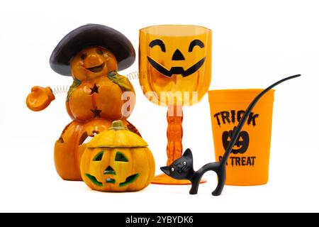 Halloween-Display mit einem Jack o Laterne, Kürbiskerzenhalter, kürbisförmigem Plastikbecher und einer schwarzen Katzenfigur auf weißem Hintergrund Stockfoto