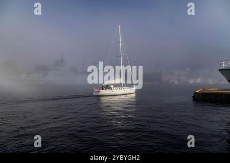 Segelboot erster Spieler im Hafen von Bergen, Norwegen. Ein Herbsttag mit dickem Nebel rund um den Hafen Stockfoto