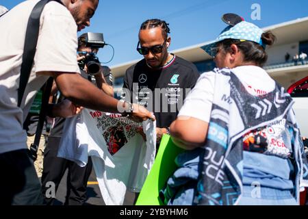 Austin, Usa. Oktober 2024. Der britische Formel-1-Pilot Lewis Hamilton von Mercedes-AMG Petronas unterzeichnet ein Autogramm für einen Marshal vor der Fahrerparade beim Formel-1-Grand-Prix der Vereinigten Staaten auf dem Circuit of the Americas in Austin, Texas am Sonntag, den 20. Oktober 2024. Foto: Greg Nash/UPI Credit: UPI/Alamy Live News Stockfoto