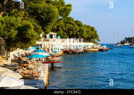 Menschen genießen die Sonne am Bonj Beach, Stadt Hvar, Insel Hvar, Kroatien Stockfoto