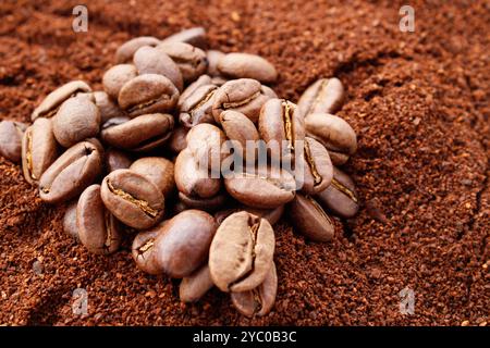Kaffeekörner auf gemahlenem Kaffee Hintergrund Stockfoto