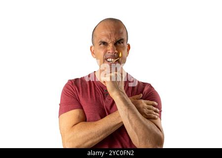 48-jähriger brasilianischer Mann, mit Blick auf die Kamera und einem beleuchteten Streichholz im Mund 4. Stockfoto