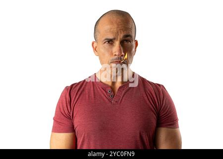 48-jähriger brasilianischer Mann, mit Blick auf die Kamera und einem beleuchteten Streichholz im Mund 7. Stockfoto