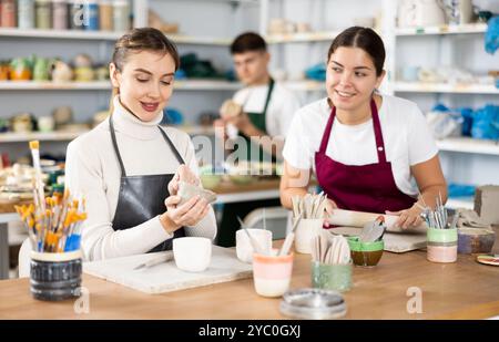 Zwei junge Frauen, die Töpferwaren in der Werkstatt herstellen Stockfoto