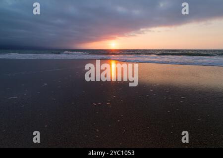 Ein wunderschöner Sonnenuntergang Natur Break Scenic mit Lichtreflexen vor dem glitzernden Sand am Meer Stockfoto