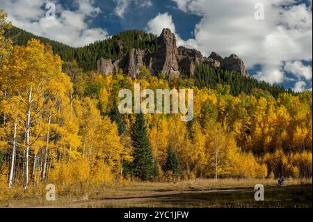 Aspen in voller Farbe vor Klippen und Gipfeln aus vulkanischem Tuff nahe dem Silverjack Lake in den San Juan Mountains von Colorado Stockfoto