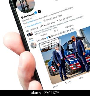 Ukraine. Poltava. Oktober 2024. Eine Hand hält ein Smartphone, auf dem sich die Twitter-Seite von Elon Musk mit einem neuen Tweet befindet. Isoliert auf einem Stockfoto