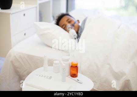 Afrikanischer Junge mit Grippe mit Vernebler zu Hause im Bett Stockfoto