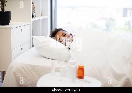 Junge, der Vernebler benutzt, während er zu Hause im Bett ruht Stockfoto