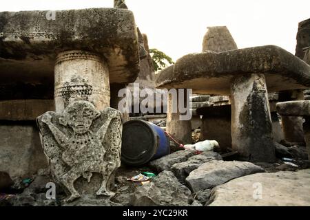 Steinschnitzerei einer menschlichen Figur vor einem megalithischen Dolmen im traditionellen Dorf Tarung in Waikabubak, Sumba Island, Indonesien. Stockfoto