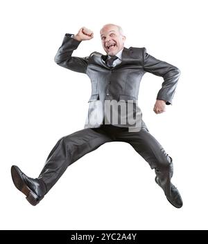 Ein leitender Geschäftsmann springt vor Begeisterung und feiert Erfolg in einem Anzug. Seine Energie und Freude glänzen vor einem weißen Hintergrund, verkörpert einen Corporate winn Stockfoto