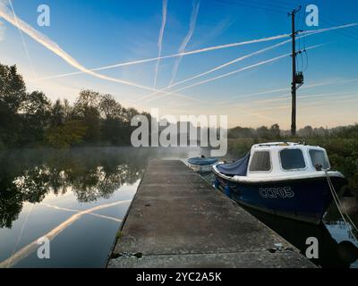 Sonnenaufgang über einem wunderschönen Abschnitt der Themse am Radley Boathouse. Das 1921 gegründete Bootshaus dient seit mehr als einem Jahrhundert für Radley College und lokale Ruderfreunde. Wenn Sie auf dem Steg stehen und an einem nebeligen Herbstmorgen flussaufwärts schauen, werden Sie das sehen. Stockfoto