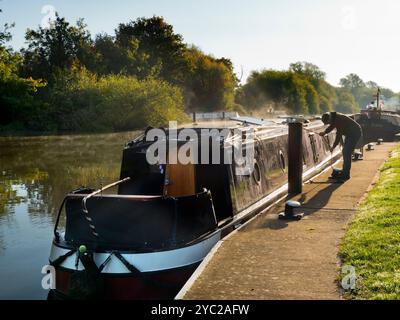 Hausboot wird an der Themse durch Abingdon Lock vertäut. Abingdon-on-Thames behauptet, die älteste Stadt Englands zu sein. Und die Themse fließt durch ihr Herz. In dieser idyllischen Szene sehen wir von Abingdon Weir aus einen erholsamen Blick auf den Fluss, an einem nebeligen, stimmungsvollen Morgen, während ein Hausboot anlegt. Stockfoto