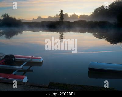 Sonnenaufgang über einem wunderschönen Abschnitt der Themse am Radley Boathouse. Das 1921 gegründete Bootshaus dient seit mehr als einem Jahrhundert für Radley College und lokale Ruderfreunde. Wenn Sie auf dem Steg stehen und auf das Nordufer des Flusses blicken, sehen Sie diesen isolierten und ziemlich schönen Baum, der sich das ganze Jahr über verändert. Besonders schön kann es bei Sonnenaufgang sein - wie hier. Stockfoto