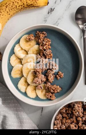 Spirulina Smoothie Schüssel mit Bananenscheiben und Müsli Stockfoto