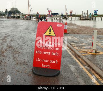 Ein Warnschild, nicht am Hafenkanal zu parken, da die Fluten an der Küste von Norfolk in Blakeney, Norfolk, England, Großbritannien, stark sind. Stockfoto