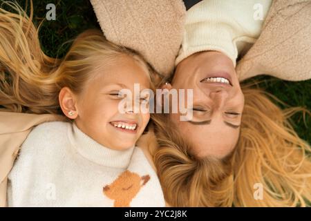 Mutter und Tochter haben Spaß in der Wiese liegend Stockfoto