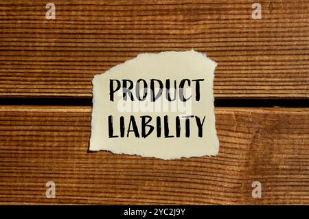 Produkthaftungsnachricht auf zerrissenem Papier mit hölzernem Hintergrund. Symbol für konzeptionelle Produkthaftung. Kopierbereich. Stockfoto