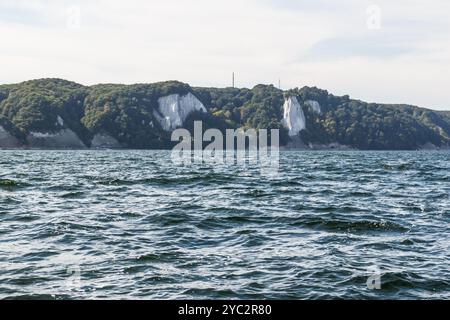 Weiße Kreidefelsen an der Rügener Küste ragen majestätisch über dem dunkelblauen Wasser der Ostsee, umgeben von üppigem Grün unter einem hellen, Stockfoto