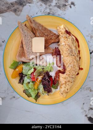 Frühstück mit Eiern, Salaten, Brot und Butter Stockfoto