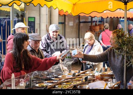 Stroud ist eine wohlhabende Stadt in Cotswold in Gloucestershire, Großbritannien, eine Kashless-Transaktion am stroud Market Olive Stall Stockfoto