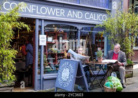 Stroud, eine wohlhabende Stadt in Cotswold in Gloucestershire, Großbritannien, liest die Zeitungen am samstagmorgen vor Cornflower und Calico Stockfoto