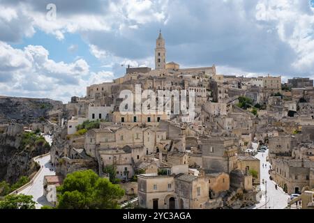 Eingebettet im Herzen von Apulien besticht Matera mit seiner alten Architektur und seinen verwinkelten Straßen, während dramatische Wolken über den Wänden eine atemberaubende Kulisse bilden, die diese zeitlose Landschaft unterstreicht. Stockfoto