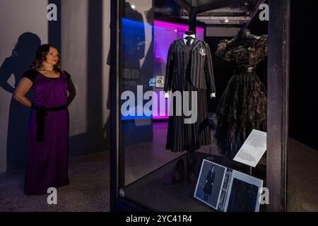 London, Großbritannien. 21. Oktober 2024. Ein Mitarbeiter sieht die Nevermore Schuluniform von Kostümdesignerin Colleen Atwood für den Film „Wednesday“, 2022 und 2025, bei einer Vorschau auf die World of Tim Burton Ausstellung im Design Museum. Tim Burton ist in erster Linie für seine filmische Arbeit bekannt und selbst ein multidisziplinärer Künstler. 600 Objekte aus seinem persönlichen Archiv, die sich über 50 Jahre erstrecken, werden vom 25. Oktober 2024 bis 21. April 2025 in Großbritannien erstmals ausgestellt. Quelle: Stephen Chung / Alamy Live News Stockfoto