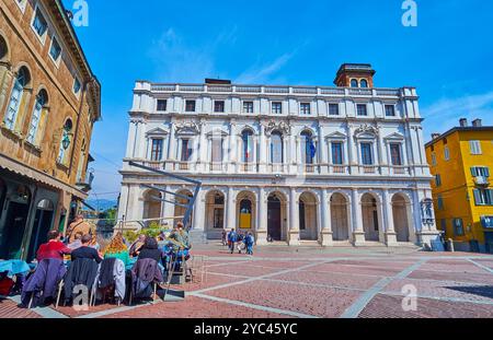 BERGAMO, ITALIEN - 7. APRIL 2022: Die gemütlichen Abendessen im Freien entlang der historischen Häuser auf der Piazza Vecchia in Bergamo Alta, Italien Stockfoto