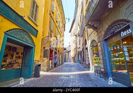 Gehen Sie entlang der alten Stadthäuser, Cafés, Geschäfte und Touristenstände an der Via Gombito in Bergamo, Italien Stockfoto