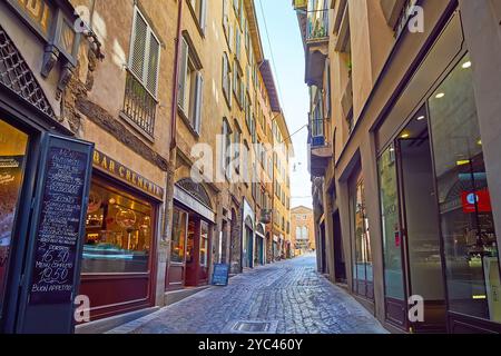 BERGAMO, ITALIEN - 7. APRIL 2022: Die schattige Via Gombito Straße in Citta Alta (Oberstadt) von Bergamo, gesäumt von hohen Stadthäusern, kleinen Geschäften und Stockfoto