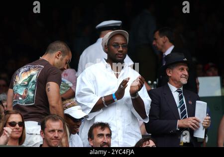 Der britische Boxer Lennox Lewis mit Serena Williams (Sitzplatz) am Wimbledon Tennis Tournament Centre Court 2002 Stockfoto