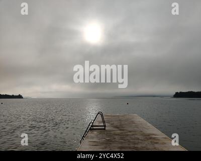 Entspannende nebelige Sommerszene im Norden mit Badeplattform, Ponton oder Holzpier mit einer Stahlleiter in die Ostsee. Sommerferien in Stockfoto